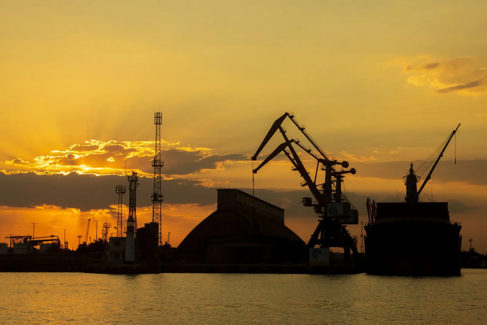 Portiques de déchargement d'un port au coucher du soleil